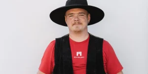 Mitarbeiter in Zimmererkluft vor grauer Wand