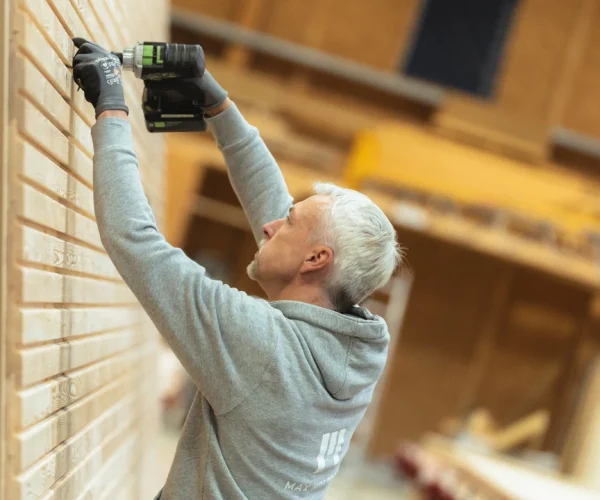 Montage der Holzfassade in der Produktion